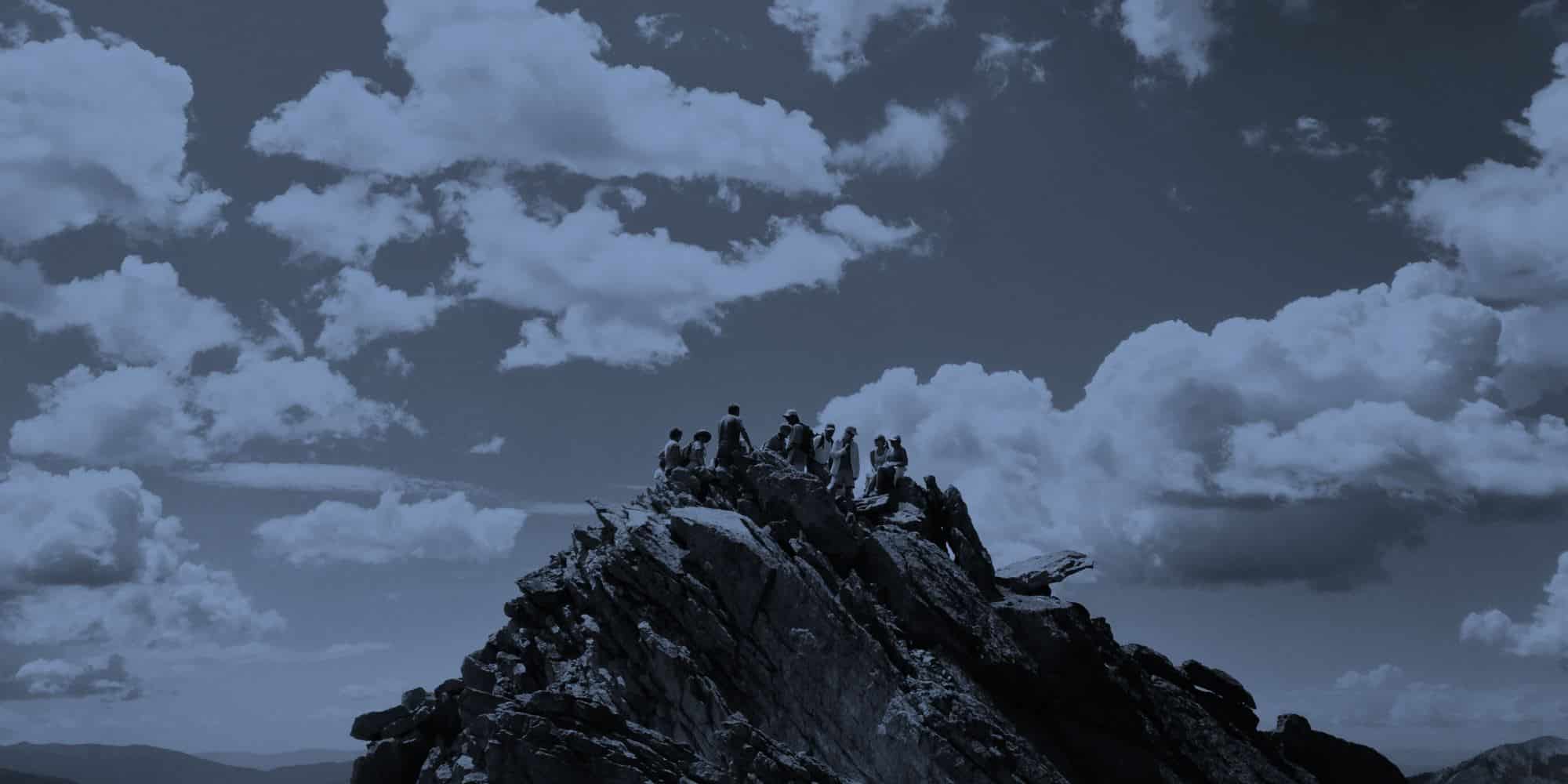 mehrere Personen sitzen auf einem Berggipfel / Führung durch OKR (Objectives and Key Results)
