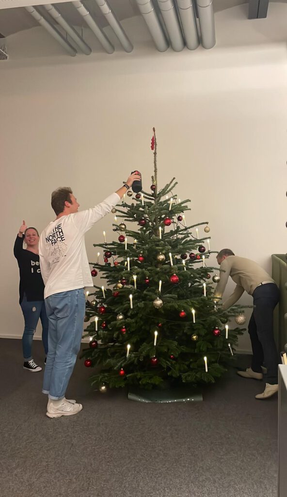 Team schmückt im Wangener Büro den Christbaum